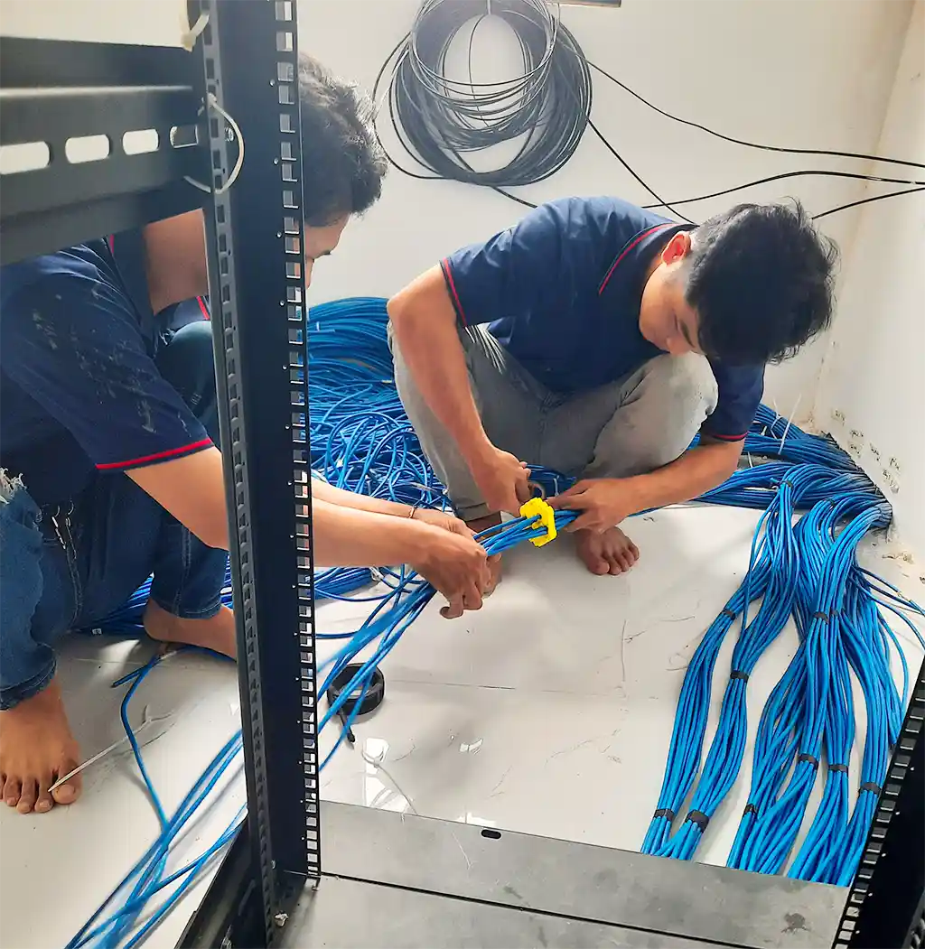 Kỹ thuật viên đang phân luồng, bó gọn dây cáp mạng bằng dụng cụ chuyên dụng để đảm bảo tính thẩm mỹ và dễ bảo trì.